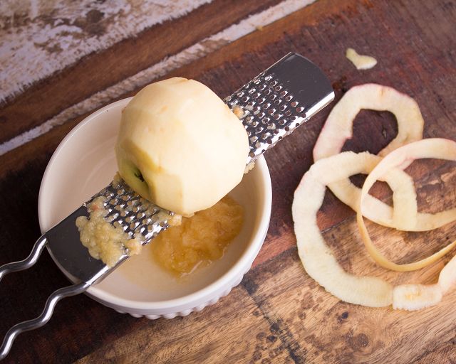 Apfel schälen und auf einer Reibe zu Mus zerkleinern