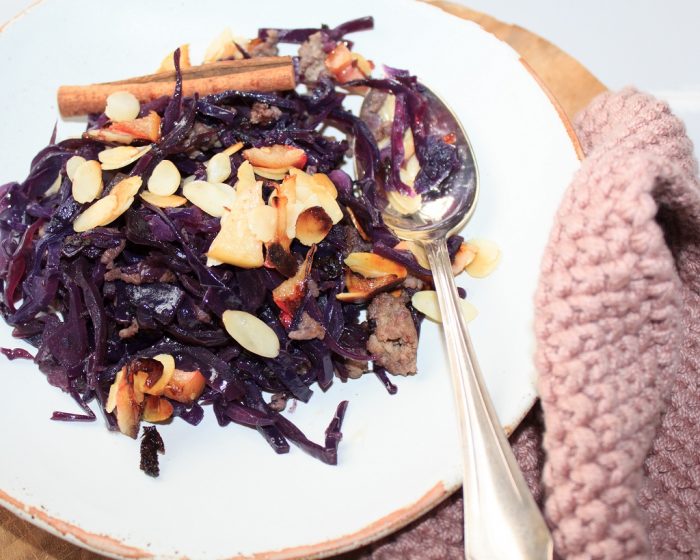 Auf einem Teller liegt Low Carb - Rotkohl-Eintopf mit Apfel-Mandel-Streuseln