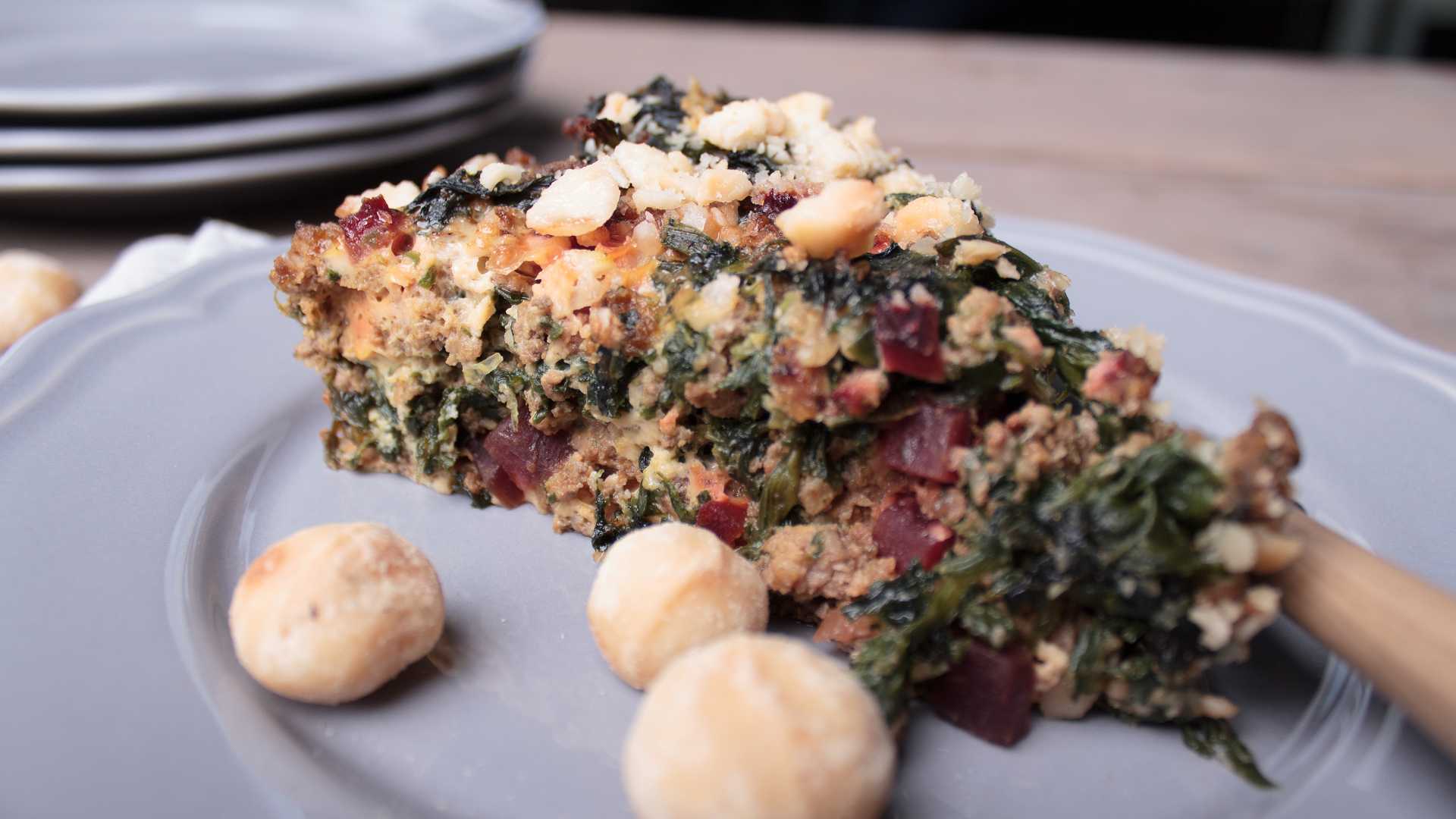 Auf einem Teller liegt ein Stück bodenlose Gemüse-Hackfleisch-Quiche