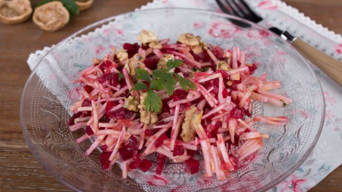 Auf einem Glasteller ist ein Wintersalat mit Sellerie und Rote Bete angerichtet